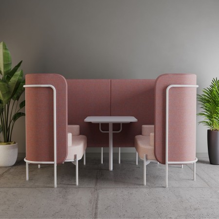Alcôve Fora rose foncé avec table intégrée, utilisée comme espace de réunion dans un environnement cosy. - Fora