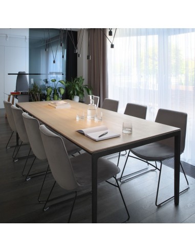 chaises de réunion Lumi autour d’une grande table de conférence en bois