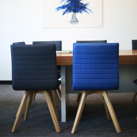 Salle de réunion avec chaises bleues et pieds en bois pour espaces professionnels