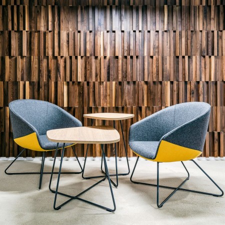 Espace d'accueil à Berne avec chaises design colorée et pieds tringle en métal