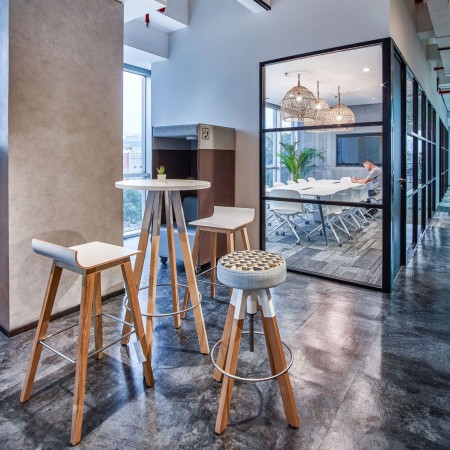 Salle de pause en entreprise lausannoise avec tabourets hauts réglables pivotants Spin