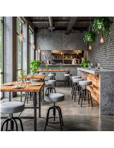 Tabourets réglables Spin avec assise tissu dans un restaurant au style industriel à Lausanne.