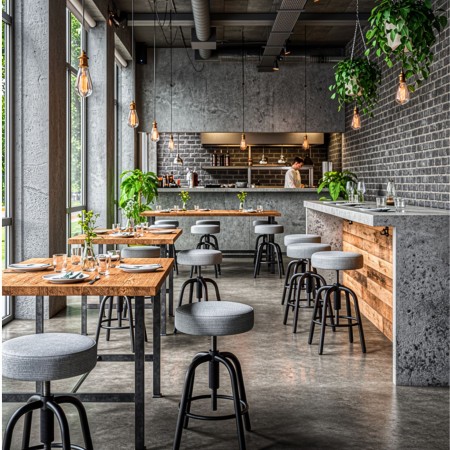 Tabourets réglables Spin avec assise tissu dans un restaurant au style industriel à Lausanne.