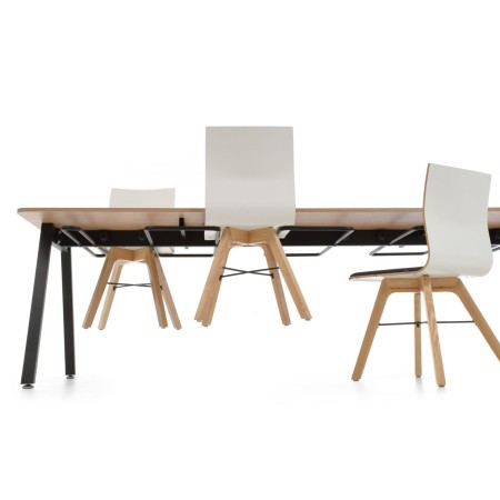 Table cafétéria entreprise Orte avec chaises suspendues sous le plateau.