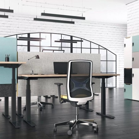 Bureau réglable en hauteur avec cloison grise et chaise ergonomique noire coworking à Genève.