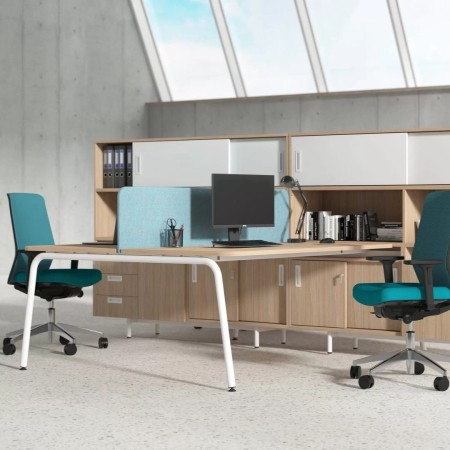 Bureaux partagés avec cloisons bleues, fauteuils ergonomiques turquoise et rangements bois ROUND à Lausanne.