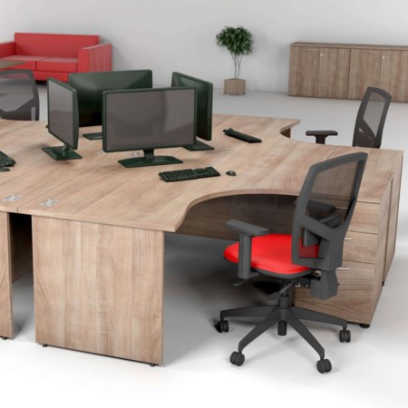 Bureau d’angle Optima Plus en bois clair avec plateau courbe, structure panneau et passe-câbles intégrés. 2