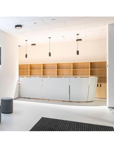 Comptoir de réception TERA d’angle dans un espace d’accueil professionnel en Suisse romande.