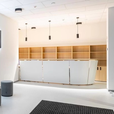 Comptoir de réception TERA d’angle dans un espace d’accueil professionnel en Suisse romande.
