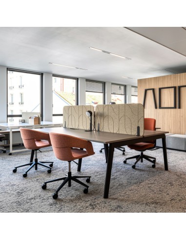 Écran acoustique central haut Round Pet en feutre PET beige avec motif FLOW sur bench de travail à Fribourg.