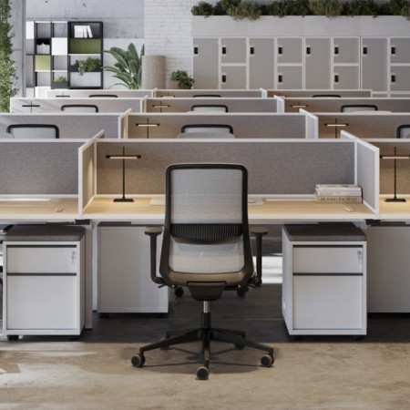 Chaise de bureau EIRA installée dans un open space professionnel avec postes de travail partagés et panneaux.
