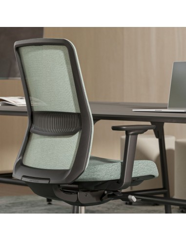 Chaise de bureau ergonomique EIRA avec dossier résille installé à un bureau à Lausanne.