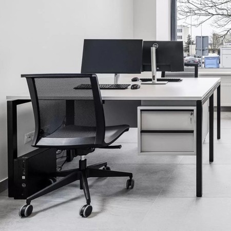 Siège ergonomique pour bureau noir avec roulettes design EVA dans un bureau minimaliste à Sion.