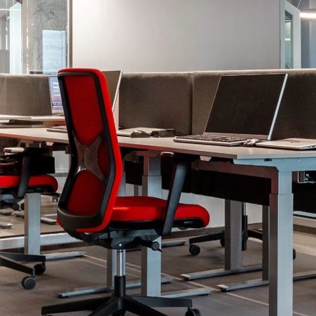 Siège de travail WIND avec dossier rembourré rouge et soutien lombaire intégré dans un bureau professionnel.