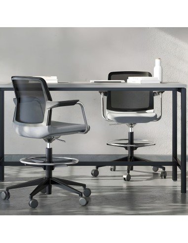 Chaise haute WIND sur roulettes devant une table de réunion haute dans un bureau à Genève.