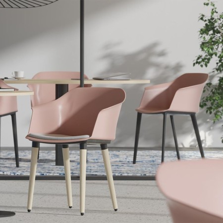 Salle d'accueil avec chaises POLYTONE C en plastique rose et pieds en nylon noir.