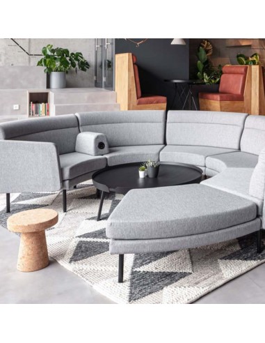 Canapé modulaire ARCIPELAGO en configuration circulaire avec tablette intégrée et assises courbes à Sierre.