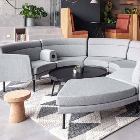 Canapé modulaire ARCIPELAGO en configuration circulaire avec tablette intégrée et assises courbes à Sierre.