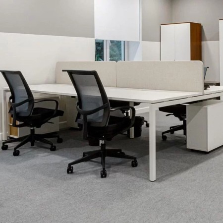 Espace de travail avec bench 4 postes NOVA et panneaux acoustiques TOP 530 gris à Nyon.