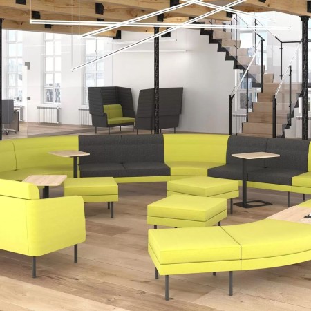 Canapé ARCIPELAGO jaune et noir avec repose-pieds jaunes carrés dans un espace professionnel à Berne.