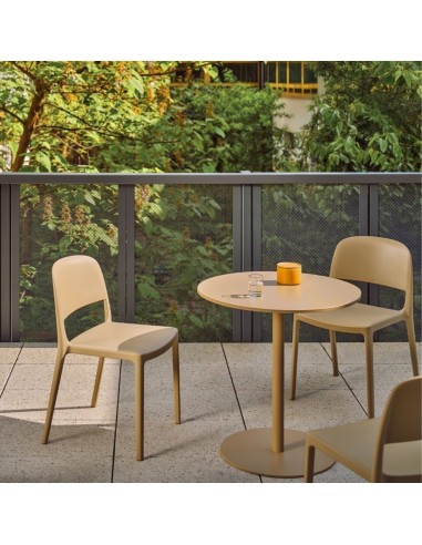Chaises Blendy beige sans accoudoirs aménagées autour d’une table sur une terrasse d’entreprise.