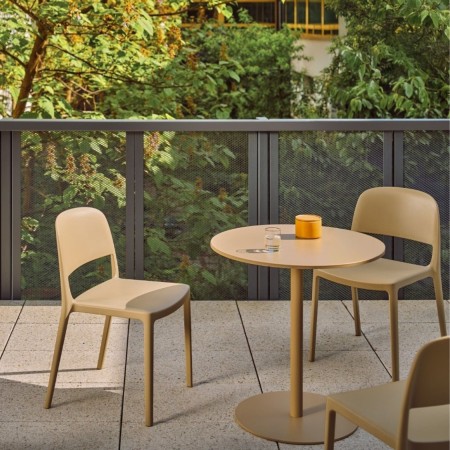 Chaises Blendy beige sans accoudoirs aménagées autour d’une table sur une terrasse d’entreprise.