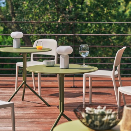 Chaises Blendy gris clair sans accoudoirs aménagées autour de tables rondes sur une terrasse extérieure.