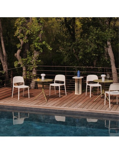 Chaises Blendy gris clair sans accoudoirs aménagées sur une terrasse lounge d’hôtel au bord d’une piscine.