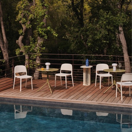 Chaises Blendy gris clair sans accoudoirs aménagées sur une terrasse lounge d’hôtel au bord d’une piscine.