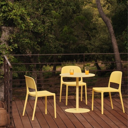Chaises Blendy jaunes sans accoudoirs pour terrasse de restaurant ou d’hôtel autour d’une table extérieure.