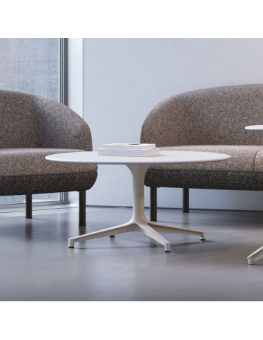 Table basse ronde BOTANY entre des fauteuils lounge dans un espace d’accueil professionnel à Neuchâtel.