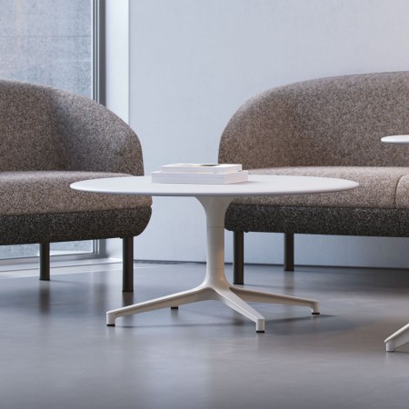 Table basse ronde BOTANY entre des fauteuils lounge dans un espace d’accueil professionnel à Neuchâtel.