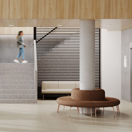 Module canapé coin extérieur arrondi avec dossier autour d'un pilier dans un hall à Fribourg.