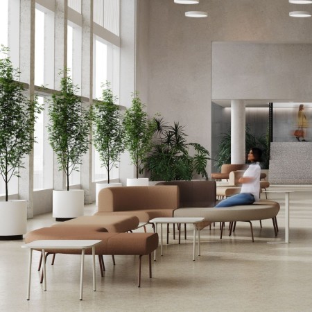 Composition de canapés modulaires LINJE avec modules courbes dans un espace lounge professionnel.