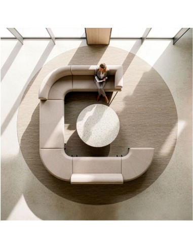 Vue de dessus d’un canapé modulable beige en configuration ouverte autour d’une table basse ronde.