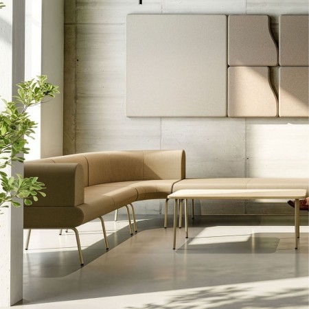 Canapé modulable beige LINJE assises courbes et table basse installé dans un espace lounge professionnel lumineux à Lausanne.