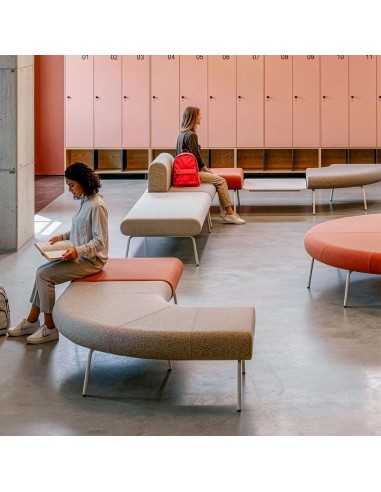 Banquettes modulables LINJE aux formes courbes aménagées dans un espace d’attente collectif avec casiers à Genève.
