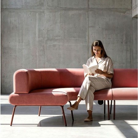 Canapé LINJE modulable rose à dossier arrondi installé dans un espace d’attente professionnel contemporain à Genève.