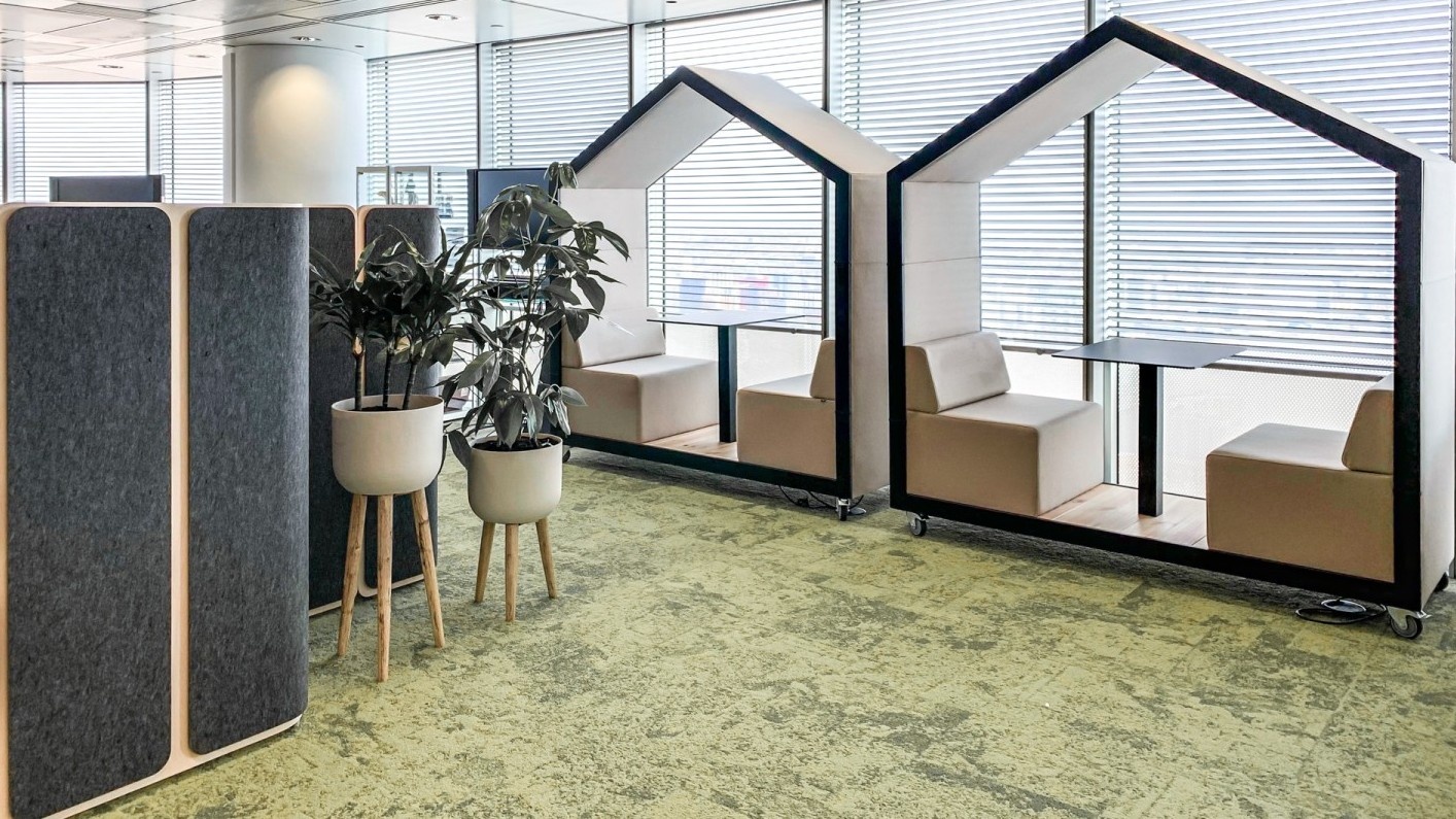 Open space d’entreprise en Suisse avec bureaux assis debout et postes de travail ergonomiques