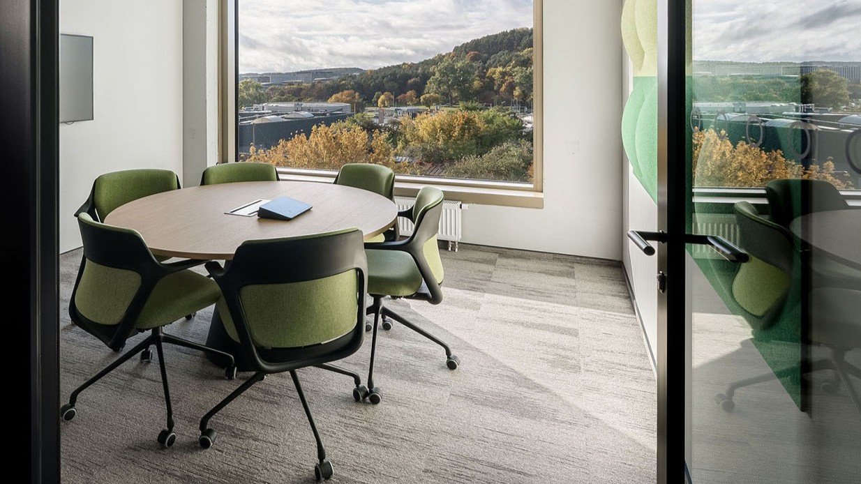 Aménagement de bureaux en open space en Suisse avec bureaux assis debout et panneaux acoustiques